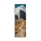 The Way Through Stone, tall wrapped canvas print: a stone-paved path passing between two massive rock towers under cumulus clouds.
