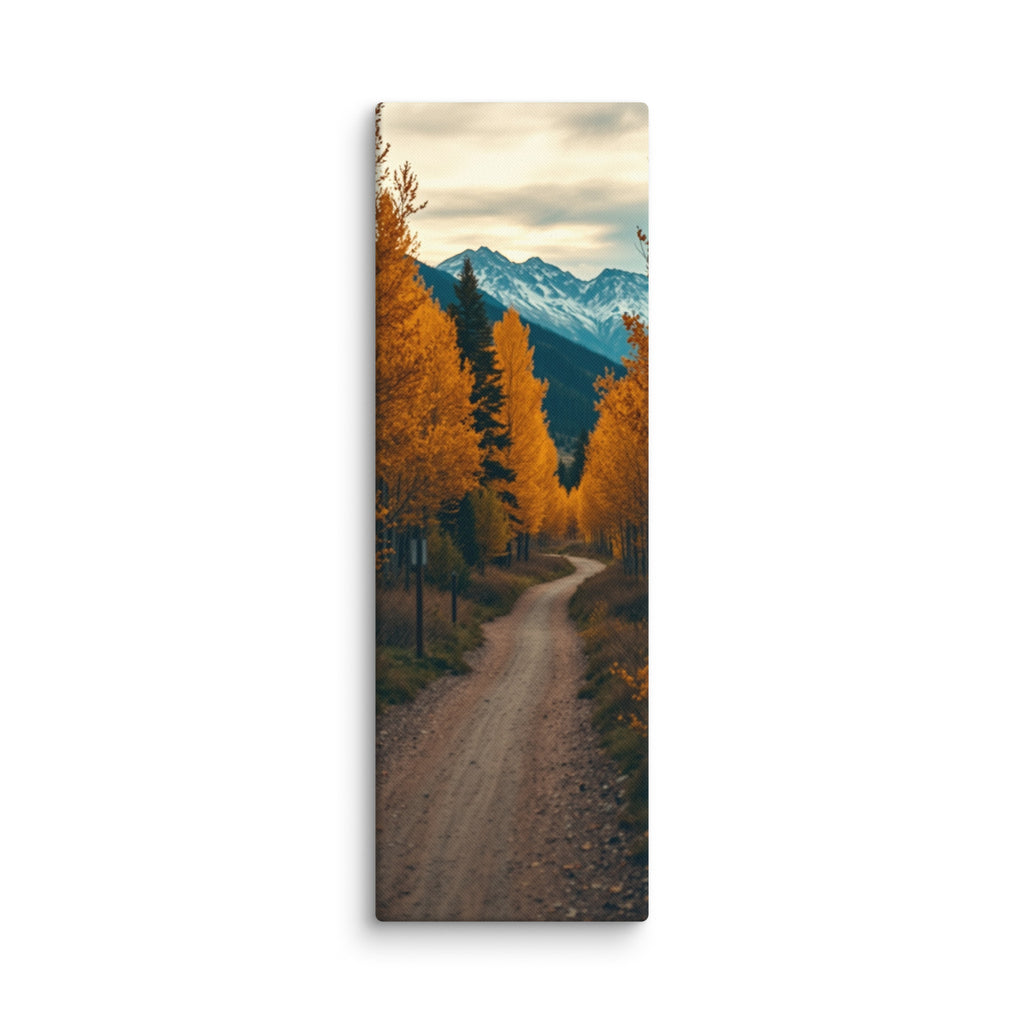 Through Amber Woods, tall wrapped canvas print: a curving dirt road through golden autumn trees toward snow-capped mountains.