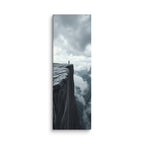 At The Brink, tall wrapped canvas print: a lone figure standing at the edge of a sheer dark cliff above a mist-filled valley.