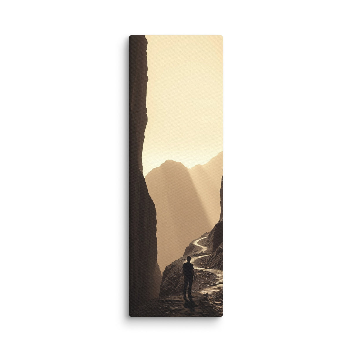 The Golden Defile, tall wrapped canvas print: a lone figure on a ridge path between dark cliffs filled with golden haze and light.