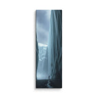 A Thread Of Water, tall wrapped canvas print: a lone figure between colossal ice walls with a thin thread of meltwater winding toward the viewer.