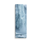 Water Held In Time, tall wrapped canvas print: a lone figure on a frozen river before a massive blue icefall with dark open water.